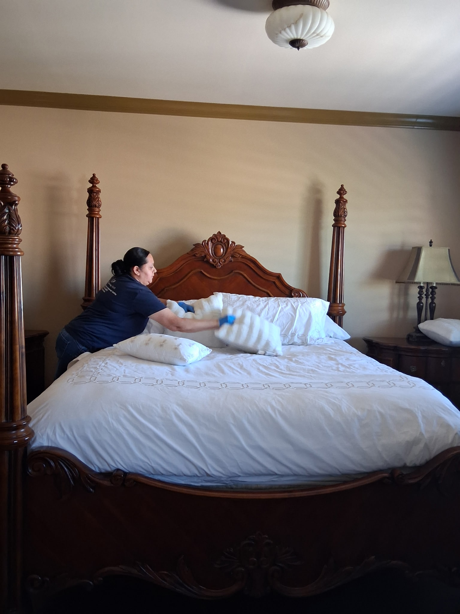 LPZ Cleaning team member making a bed in an elegant bedroom